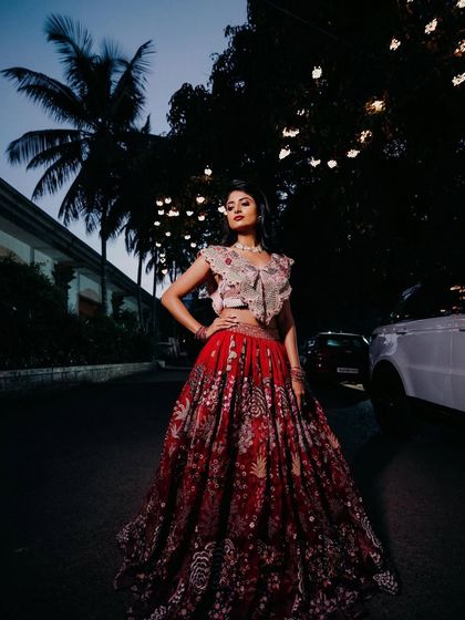 A dramatic, full-length shot of the bride. The lighting creates a moody and high-fashion feel, and her makeup looks flawless.