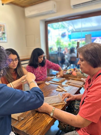 Every student gets individual attention to ensure they feel comfortable with the process. In this photo, I am guiding a participant through a weaving stitch, making sure she understands the technique before continuing on her own.