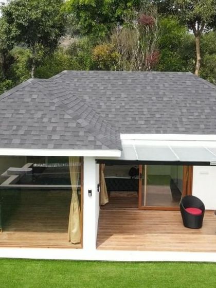 A modern cottage at Panorama Peaks, Coorg, with a private deck and large glass windows to maximize the stunning mountain views.