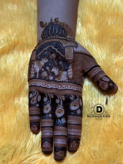 The completed Karwa Chauth design with dark, rich henna. The contrast makes the figures and patterns stand out beautifully.