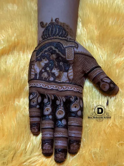 The completed Karwa Chauth design with dark, rich henna. The contrast makes the figures and patterns stand out beautifully.