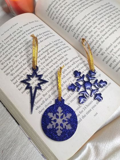 Getting ready for the holidays with these handmade Christmas ornaments. This set includes a star, snowflake, and bauble in a deep blue with glitter.