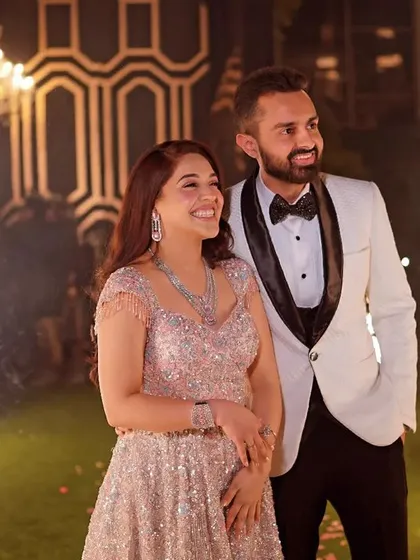 A picture-perfect reception moment. The couple smiles as sparklers go off behind them, creating a beautiful and celebratory portrait.