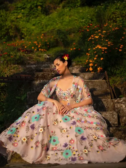 A fashion portrait from a mountain shoot with Baavli. The model is seated on stone steps, and the floral dress blends beautifully with the natural surroundings.