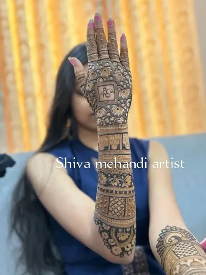 This design features the initials 'R' and 'S' in a stylish font on the back of the hand, blended seamlessly with traditional motifs.