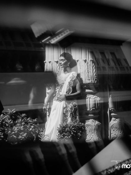 An artistic black and white portrait of the bride, captured through a reflection. This moody and elegant shot highlights the timeless beauty of the bride and the heritage location.