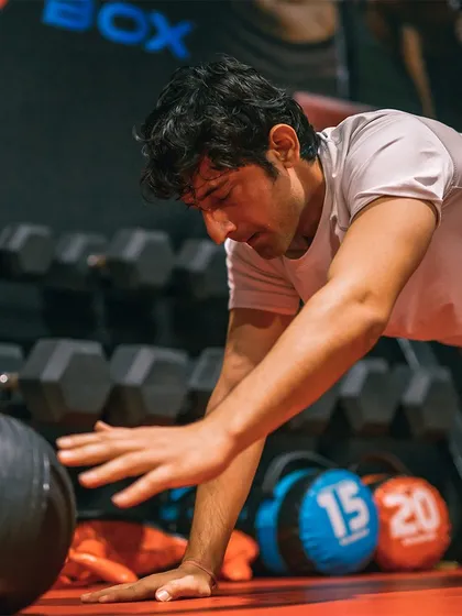 Striving for greatness means pushing through tough drills. Here, a member performs a medicine ball push-up, an advanced conditioning exercise to build explosive upper body strength for MMA.