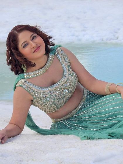 This pose highlights the full skirt and beautiful drape of the lehenga.