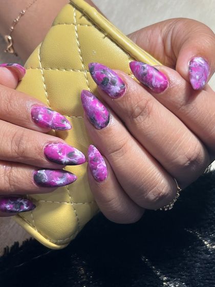 This shot shows the purple marble nails paired with a cute accessory, highlighting how they can be a stylish part of your overall look.