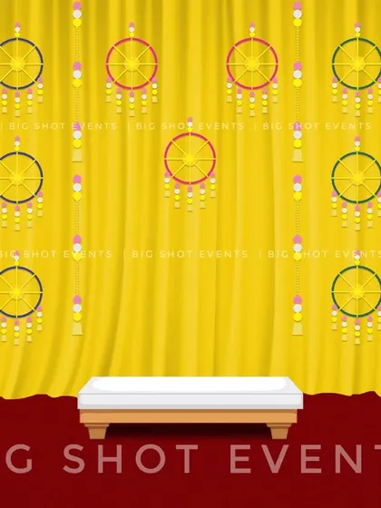 This design concept for a Haldi ceremony features hanging dreamcatcher-style wheels against a yellow curtain. It's a modern twist on traditional decor, blending classic colors with contemporary elements.