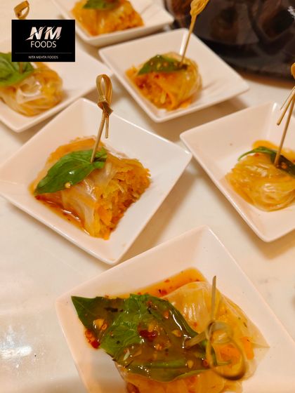 These are our Thai-style glass noodle rolls, filled with fresh vegetables and herbs. They are served with a sweet chili dipping sauce for a burst of authentic Southeast Asian flavor.