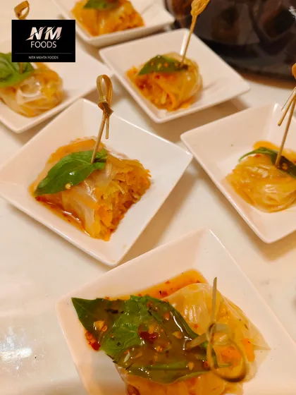 These are our Thai-style glass noodle rolls, filled with fresh vegetables and herbs. They are served with a sweet chili dipping sauce for a burst of authentic Southeast Asian flavor.