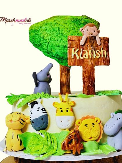 The complete animal farm cake, with a personalized wooden-style sign for Kiansh. The edible tree and leaves complete this charming woodland scene.