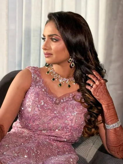 A beautiful portrait of the bride at her reception. The soft lilac tones of her dress are complemented by a pink and purple-toned makeup look.