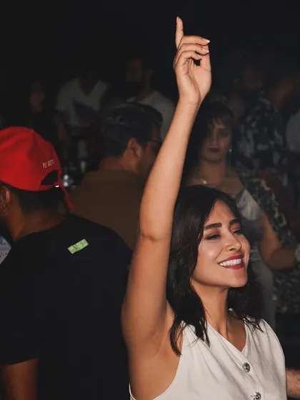A guest with her hand in the air, lost in the music.