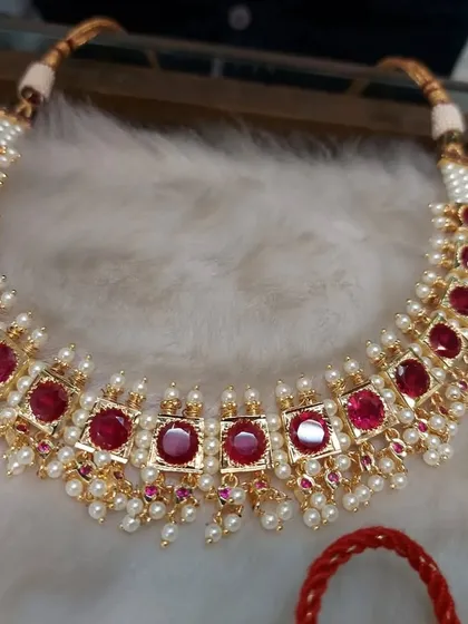 A simple yet elegant choker with red stones and pearls. This piece is versatile and can be worn by guests of all ages.