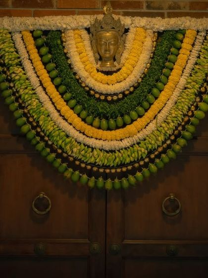 This handcrafted toran, made from fresh leaves and flowers in shades of green, yellow, and white, is a perfect example of how I blend traditional artistry with a clean, aesthetic design for a modern South Indian wedding.
