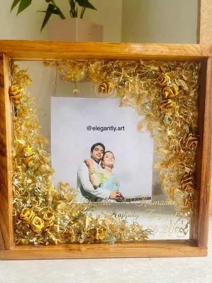 This teakwood floating frame preserves a couple's wedding garland in a unique way. The flowers appear to float around their photo, creating a light and airy feel.