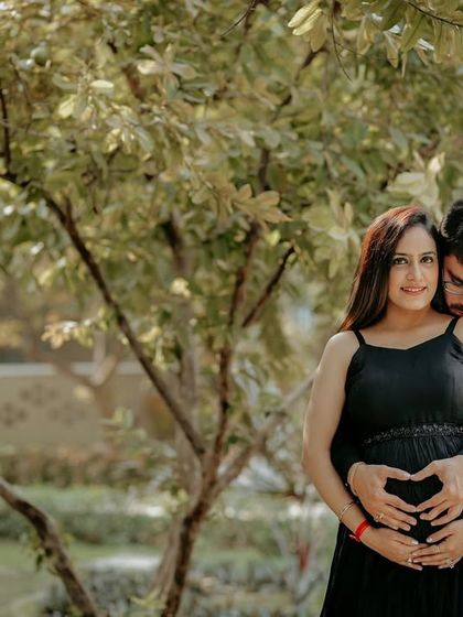 The classic heart-hands pose over the baby bump, done as a couple. This is a sweet and popular way to show your love for your growing family.