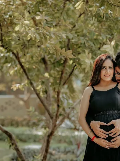 The classic heart-hands pose over the baby bump, done as a couple. This is a sweet and popular way to show your love for your growing family.