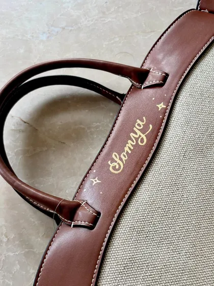 This shows my paint pen calligraphy on the leather strap of an H&M tote bag. I use a steady hand to create beautiful, flowing script, turning a simple bag into a one-of-a-kind accessory. Each design is sealed to ensure it lasts.