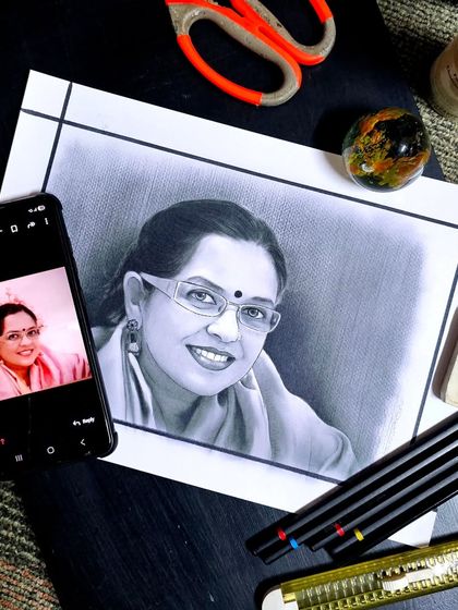 Here is a pencil and charcoal portrait I created, placed next to the reference photo on a phone. I pay close attention to details like the expression in the eyes and the gentle smile to capture the person's true spirit.