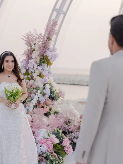 A beautiful portrait of the bride-to-be at her engagement, looking back at her partner. The soft pastel florals and ocean backdrop create a perfectly romantic scene.