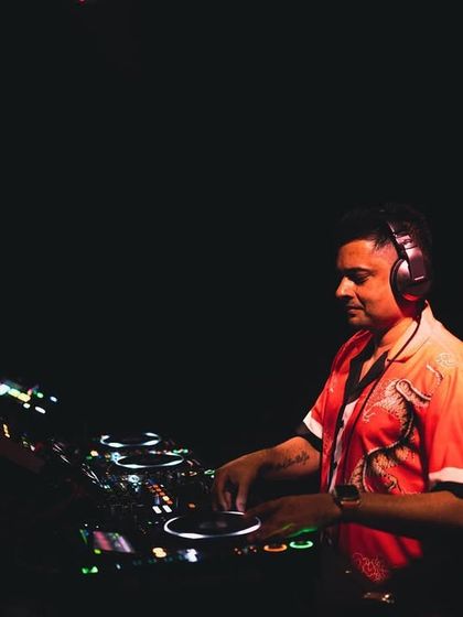 A focused, profile shot of me mixing. The warm lighting creates an intimate feel, even in a busy club.