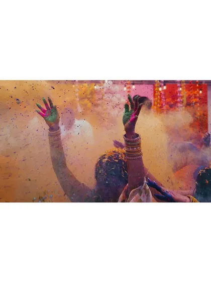 This image is pure celebration. The hands raised in the air, covered in the bright powders of the festival, symbolize the collective joy and vibrant spirit of the wedding festivities.