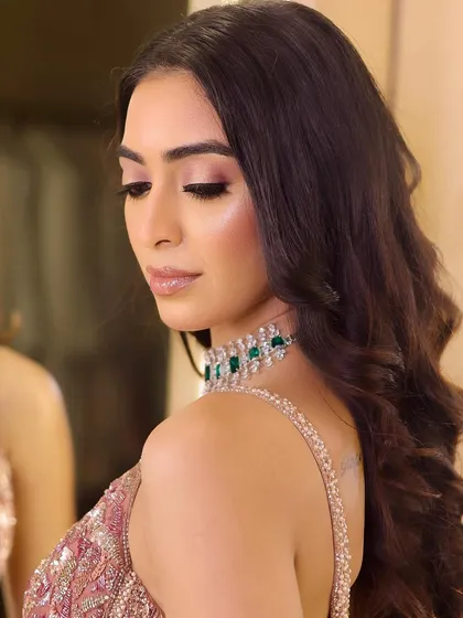 A side profile showcasing the soft waves and the beautifully blended eye makeup. This angle highlights the seamless transition of colors and the radiant skin finish.