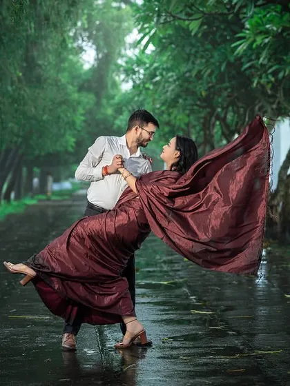 A dramatic dance in the rain. The motion of her saree and the wet, reflective path create a stunning, high-energy shot that is full of passion and filmi drama.