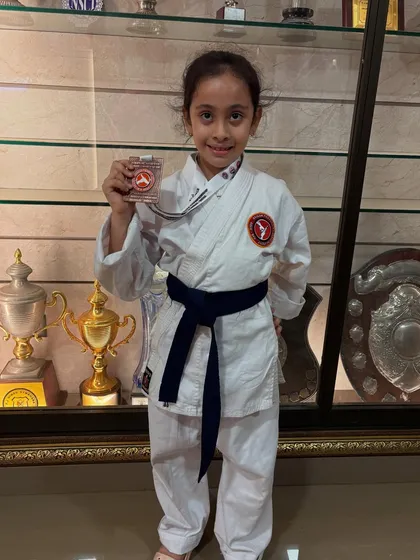 Proudly displaying her medal. This young girl's achievement at our tournament is a reflection of her dedication and the supportive environment of our dojo.