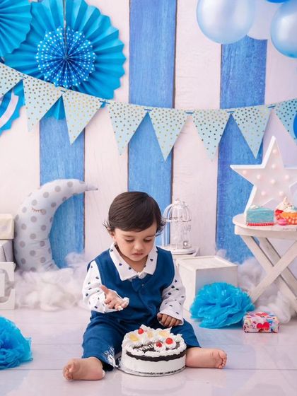 A moment of concentration as this one-year-old carefully inspects his birthday cake before the smashing fun.