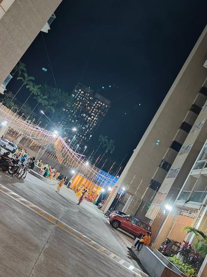 Another view of the society grounds decorated for a festival, showing the pandal and lighting from a distance.
