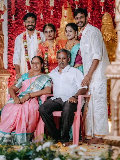 A beautiful family portrait, with the newly married couple posing with their parents and siblings.