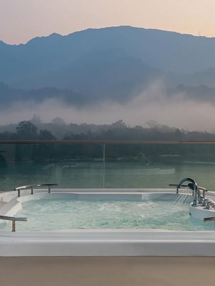 A hydrotherapy pool at the Modi Yoga Retreat in Rishikesh, overlooking the misty mountains. This space was designed as the ultimate relaxation spot, where the elegance of the retreat meets the natural beauty of the Ganges valley.