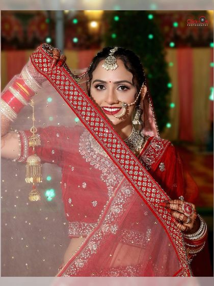 A classic bridal shot with the bride peeking through her veil with a beautiful smile.
