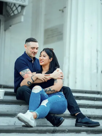 A relaxed moment on the steps of a grand Mumbai building. This candid shot shows the couple enjoying a simple, happy moment together.