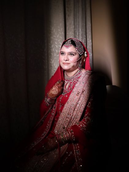A classic portrait of a Nikkah bride. The lighting highlights the beautiful details of her makeup and the rich embroidery of her dupatta.