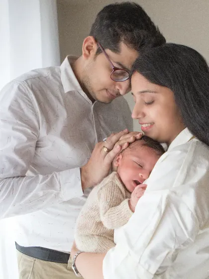 Soft light and softer emotions. This portrait captures the overwhelming love and gentleness as new parents admire their sleeping baby.