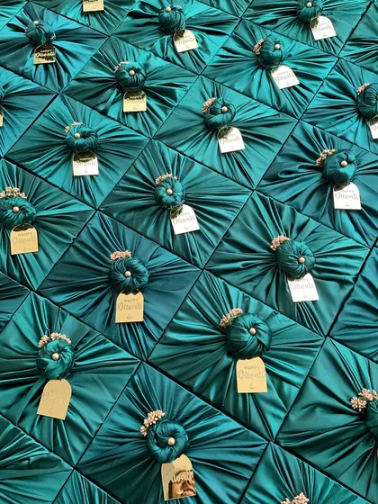 The visual impact of a bulk order is always stunning. Here is a sea of gifts, each meticulously wrapped in rich teal satin fabric with custom gold tags, ready to be dispatched for a large corporate event. This shows my capability to handle large volumes without compromising on aesthetics.
