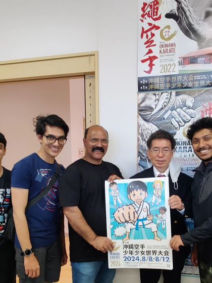 Receiving the official poster for the 2nd Okinawa Karate World Junior Tournament from Sensei Kunio Uehara at the Okinawa Karate Kaikan.