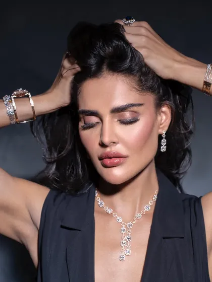 A dynamic shot with windswept hair, creating a sense of movement and freedom. The model is wearing a full set of modern diamond jewellery, styled to look effortlessly chic and powerful.