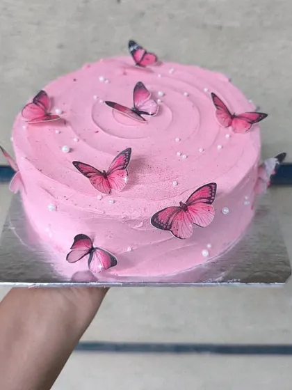 A simple yet beautiful pink butterfly cake. The soft pink buttercream is swirled on top and adorned with delicate, edible pink butterflies.