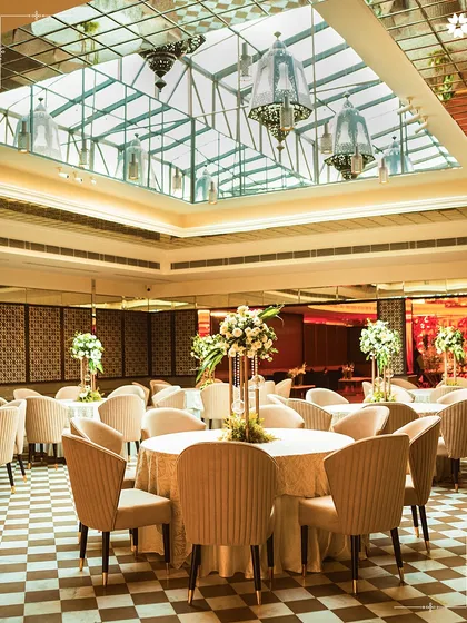 A daytime view of the main hall at Araya Bagh, New Delhi. The natural light flooding in from the glass ceiling creates a bright and airy ambiance for lunches and daytime ceremonies.