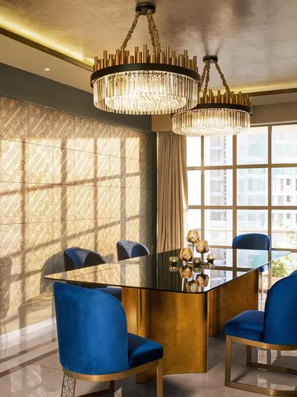 In this 'DLH' residence, the dining room is brought to life by the interplay of light and luxury. We used Versace wall tiles and grand chandeliers to create an atmosphere of elegant opulence, where natural light during the day gives way to a warm glow at night.