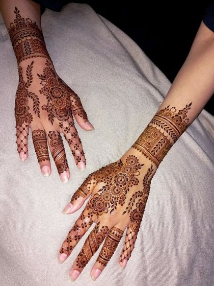 This design combines delicate floral vines with net-like patterns on the fingers. It's a beautiful and intricate choice for an engagement or for a bridesmaid.