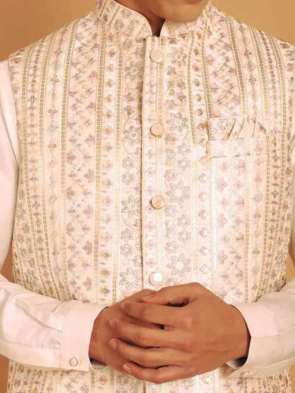 A close-up of the multi-color thread embroidery on this off-white jacket. The timeless allure of embroidery adds elegance and sophistication to your kurta set.