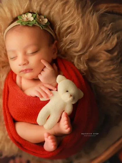 A close-up shot showing a baby's sweet expression as they hold a teddy bear. We love capturing these little interactions, even in sleep.