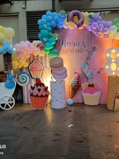 A Candyland theme featuring a sweet treats cart, perfect for displaying the cake or desserts, surrounded by pastel balloons and candy props.